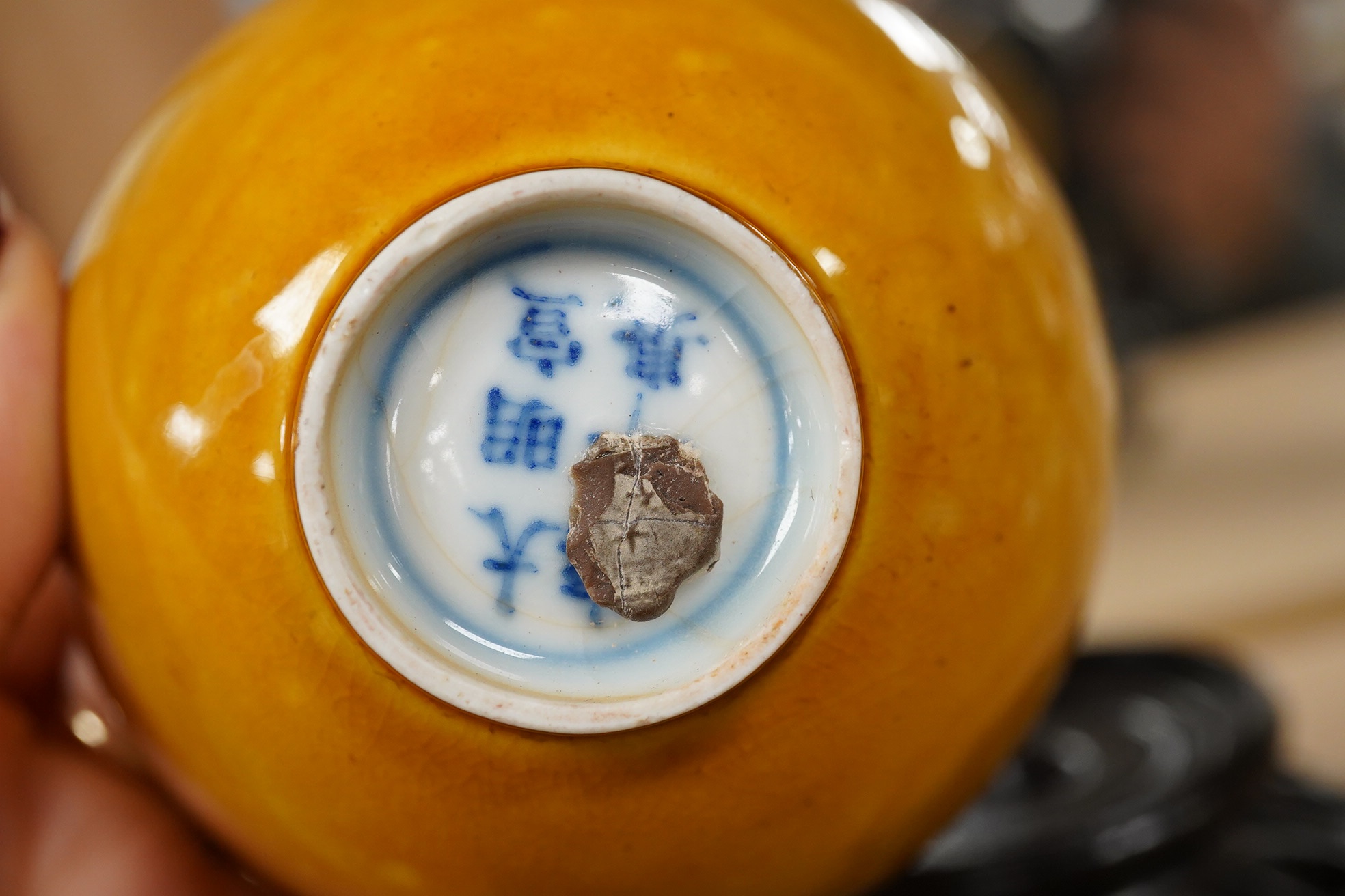 A Chinese yellow glazed teabowl on hardwood stand, 9cm diameter. Condition - fair